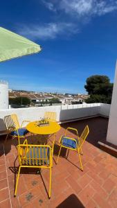 een gele tafel en stoelen op een patio bij Casa Límon in Torredembarra