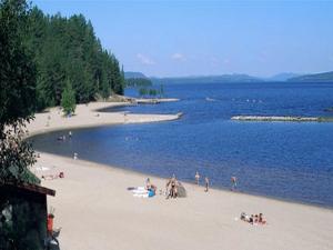 a group of people on a beach near the water at Vilan I Orbaden in Vallsta