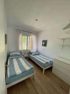 een slaapkamer met twee bedden en een raam bij Casa Límon in Torredembarra