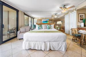 Un dormitorio con una cama grande y una sala de estar. en Mahana 913, en Kahana