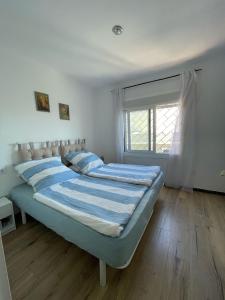 een slaapkamer met een bed met blauwe lakens en een raam bij Casa Límon in Torredembarra