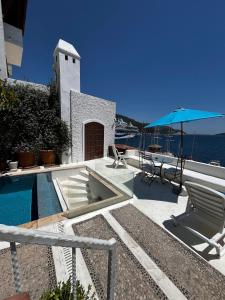 a pool with chairs and a table and an umbrella at Castle81homes White , Sea view house in Marmaris