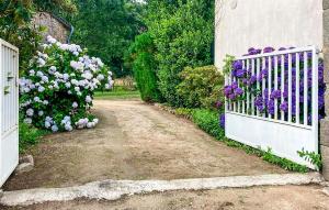 a garden with purple and white flowers and a gate at 4 Bedroom Nice Home In Trédion in Trédion +12 photos