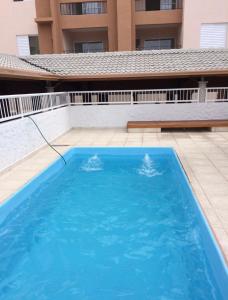 ein großer blauer Swimmingpool vor einem Gebäude in der Unterkunft Apto Ubatuba home - Centro c vista in Ubatuba