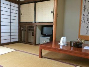 a room with a tv and a table and a table sidx sidx w obiekcie Iris Yu w mieście Hiraizumi