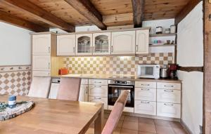 een keuken met witte kasten en een houten tafel bij Ferienwohnung Diana in Lancken-Granitz +10 foto's