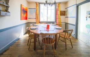 a dining room with a wooden table and chairs at Accueillante Maison Proche Mer in Carantec