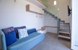 ein blaues Sofa in einem Zimmer mit einer Treppe in der Unterkunft 1 Bedroom Gorgeous Home In Castellabate in Castellabate