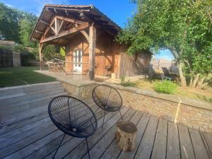 a wooden deck with two chairs and a cabin at Gîte avec spa in Saint-Avit-Sénieur