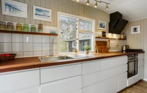 a kitchen with white cabinets and a sink at Beautiful Home In Malling in Malling +16 photos