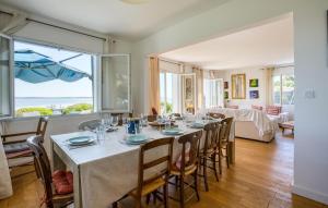 a dining room with a table with chairs and a room with a view at Awesome Home In Saint-Trojan-Les-Bains in Saint-Trojan-les-Bains