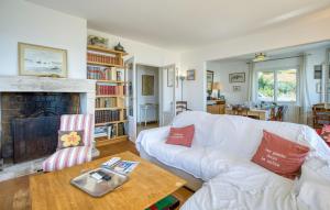 a living room with a white couch and a fireplace at Awesome Home In Saint-Trojan-Les-Bains in Saint-Trojan-les-Bains