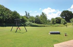 a swing set in a field of grass at Cozy Home In Rudkøbing With Sauna in Spodsbjerg +21 photos