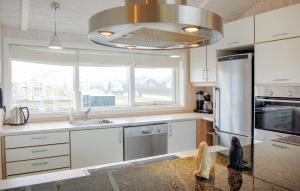 a kitchen with a stainless steel refrigerator and a window at Cozy Home In Rudkøbing With Sauna in Spodsbjerg
