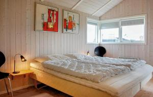 a bedroom with a bed with two chairs and a window at Cozy Home In Rudkøbing With Sauna in Spodsbjerg