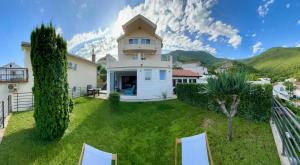 a large white house with a grass yard at Apartman Mrva in Baošići