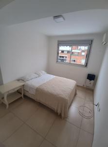a white bedroom with a bed and a window at Excelente SEMIPISO vista al Buen Pastor in Cordoba