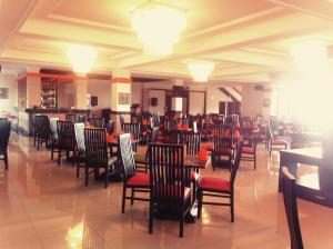 Queen Garden Hotel في باتورادن: غرفة طعام مع كراسي وطاولات في مطعم