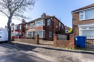 a brick house with a fence in front of it at Royal Retreat in Redcar