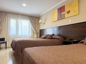 a hotel room with two beds and a window at Hotel Aire de Patagonia in Río Gallegos +36 photos