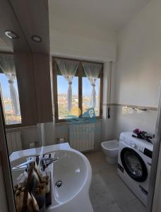 a bathroom with a sink and a washing machine at Etruscan Blue House in Piombino +18 photos