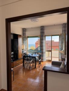 a living room with a table and chairs and a kitchen at Etruscan Blue House in Piombino