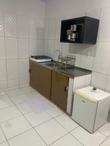 a small kitchen with a counter and a refrigerator at Casa Marajó Centro de Belém COP30 in Belém
