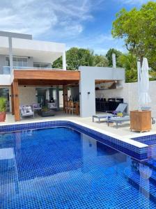 une grande piscine devant une maison dans l'établissement Casa Praiana Litoral, à Camaçari