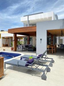 une maison avec deux chaises longues et une piscine dans l'établissement Casa Praiana Litoral, à Camaçari
