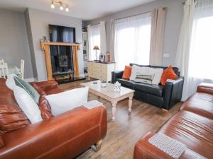 a living room with two leather couches and a coffee table at Loistin Coimin in Ballybofey
