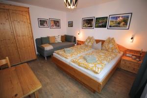 a bedroom with a bed and a couch at Zur STOCKERin - Ferienwohnung in Schladming