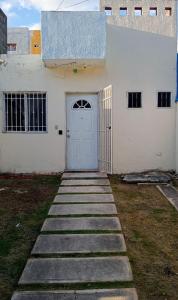 a white building with a blue door and grass at Linda Vista Garden Cancun, Privado con AC y WiFi Cerca de Transporte a Zona Hotelera in Cancún