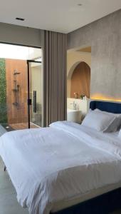 a bedroom with a large white bed and a bathroom at شاليهات نافارو in Ghurābah +80 photos
