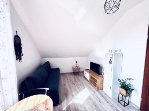 a living room with a blue couch and a tv at Apartament Salton in Bochnia