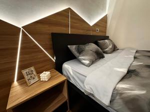 a bedroom with a bed with a wooden headboard at MAR Residence 15 in Niš