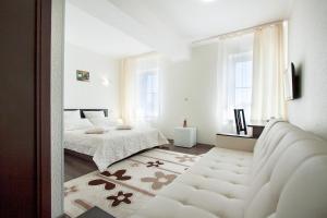 a white bedroom with a bed and a mirror at Piramida Hotel in Samara