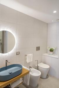 a bathroom with a blue sink and a toilet at Onda del Mare in Mazzeo