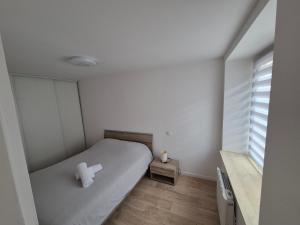 a small bedroom with a bed and a window at Appartement proche cure thermale in Bains-les-Bains