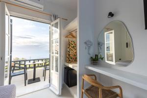 a room with a mirror and a view of the ocean at Paros Five Senses in Parikia