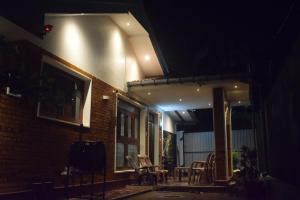 een huis verlicht in de nacht met stoelen en tafels bij Villa Green Garden in Hikkaduwa