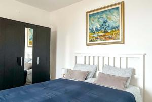 sypialnia z niebieskim łóżkiem i obrazem na ścianie w obiekcie Apartment La Perla w mieście Opatija