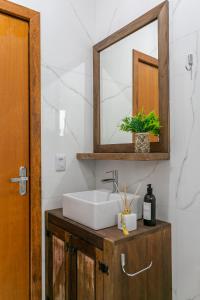 a bathroom with a sink and a mirror at RJ Residencial Beira Mar in Palhoça