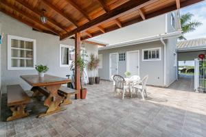 a patio with a wooden pergola and a table and chairs at RJ Residencial Beira Mar in Palhoça