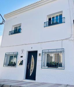 un edificio blanco con una puerta y ventanas azules en Casa Dolly Boutique B&B, en Cantoria