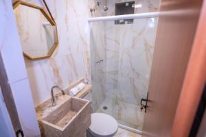 a bathroom with a marble shower and a sink at M3 Studio Hotel in Camaçari