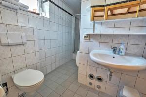 a white bathroom with a toilet and a sink at Naturlaub-Domizil Oster-Franzen in Bremm +16 photos