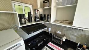 a kitchen with a stove top oven in a kitchen at Aline Duque - Flat no centro de Porto de Galinhas por Yolo in Porto De Galinhas