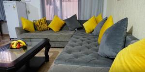 a living room with a gray couch with yellow pillows at Westminster moroc style in London