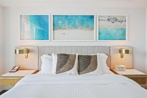 フォート・ローダーデールにあるBeachfront Ritz-Carlton Luxury 1BR Residenceのベッドルーム1室(白いベッド1台、ナイトスタンド2つ、ランプ2つ付) +24枚の写真