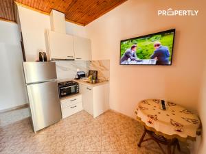 a kitchen with a refrigerator and a tv on the wall at Cypress Seaside Apartment #PROPERTLY in Nea Kallikrateia +20 photos